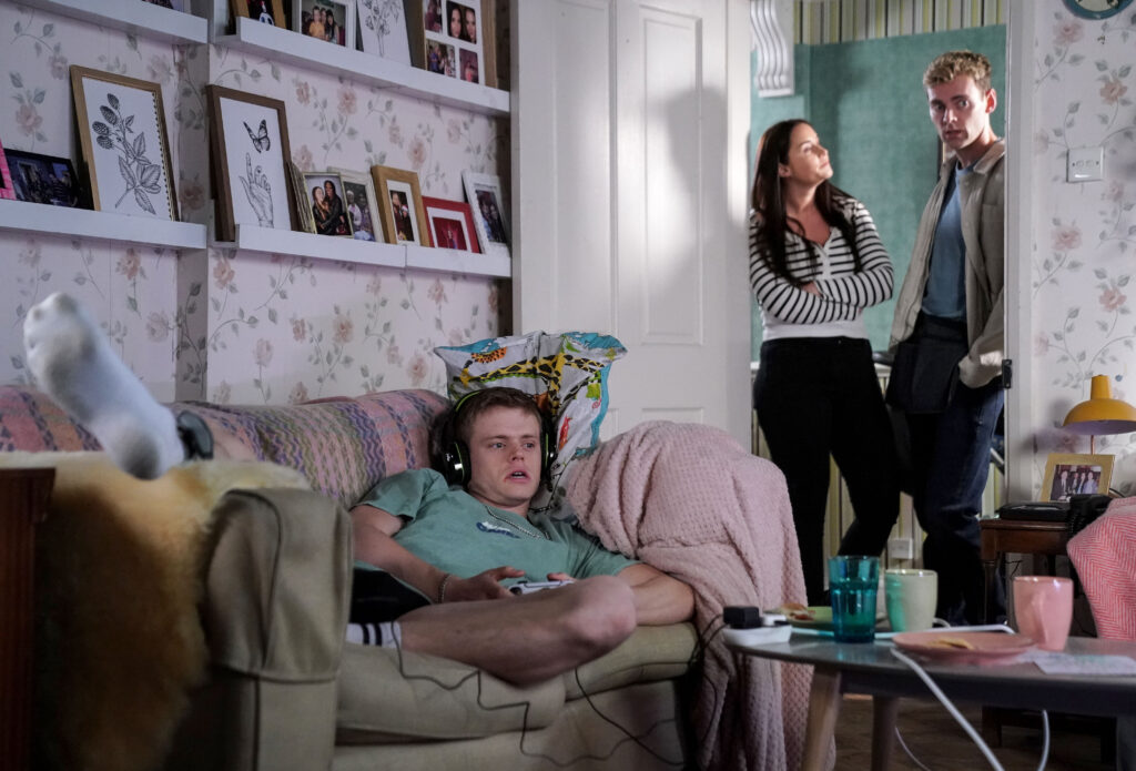 Oscar lounges on the sofa while Peter and Lauren look on disapprovingly