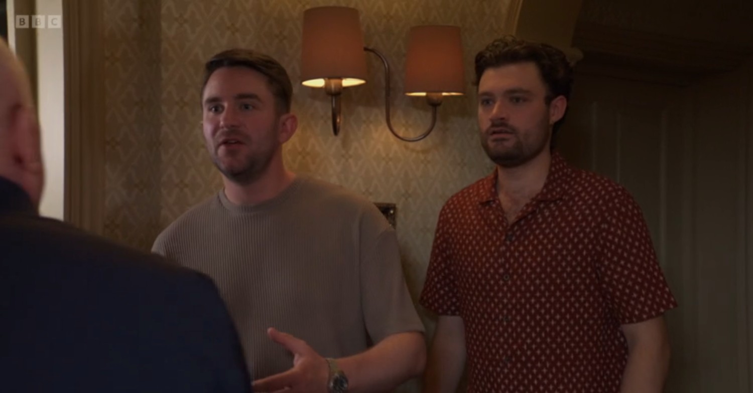 Johnny and Callum look shocked as they stand in the back of The Vic on EastEnders