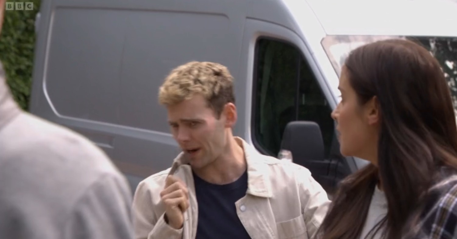 Peter speaks into his collar as he pretends to be a police officer on EastEnders