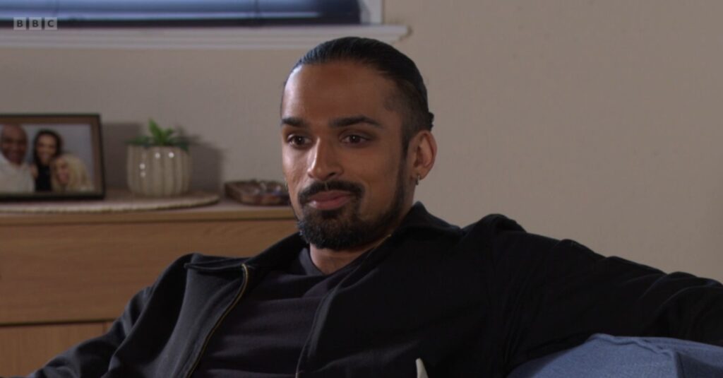 Ravi smiling smugly on EastEnders
