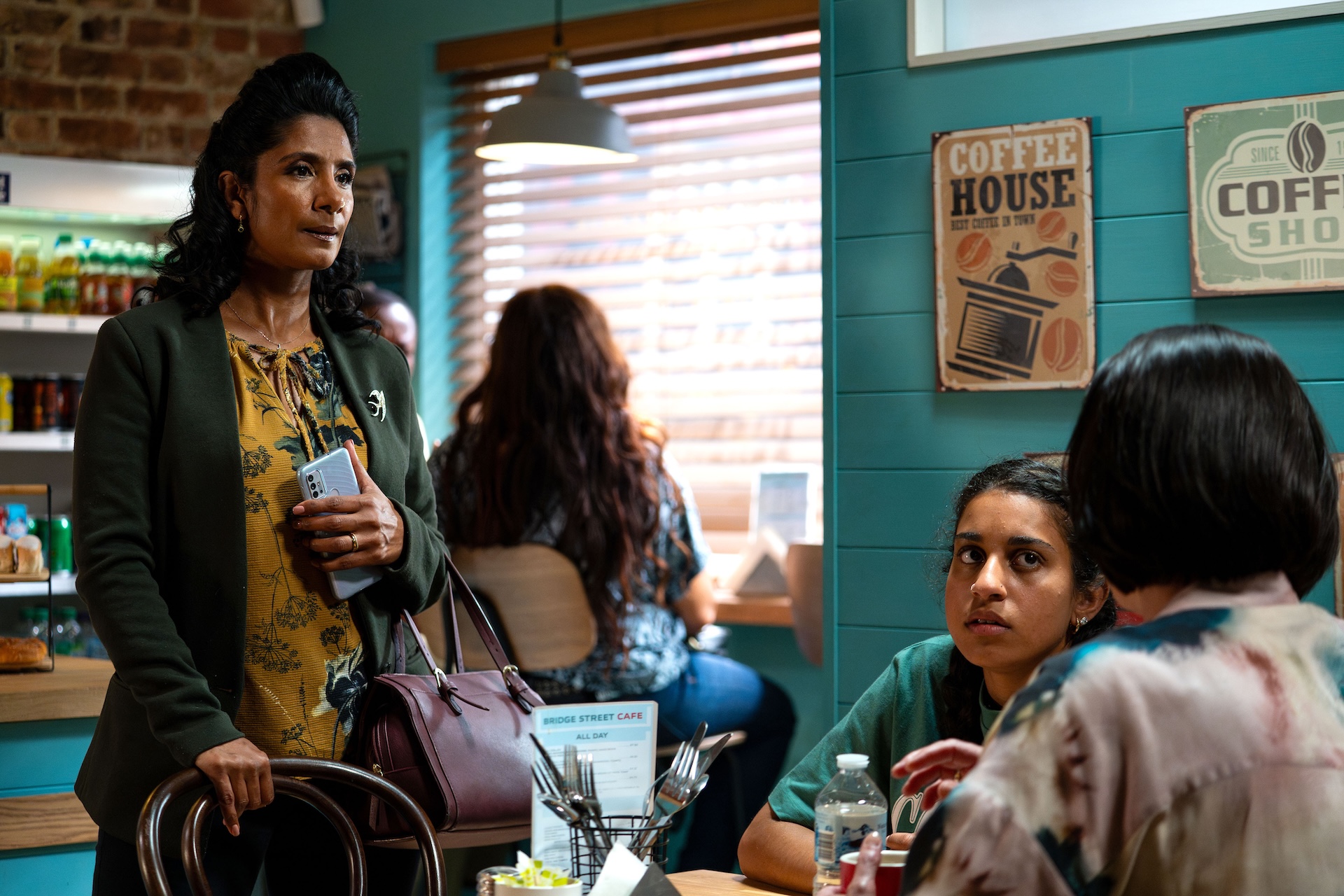 Suki looks worried as she talks to Eve and Avani in the cafe on EastEnders