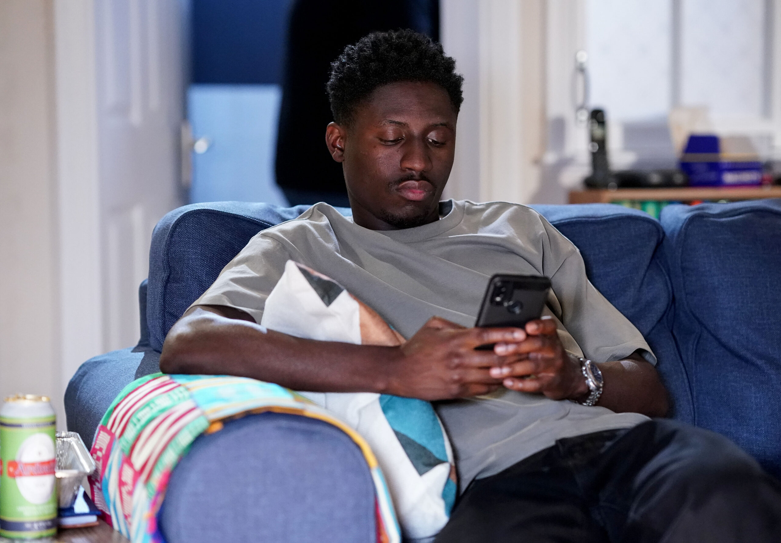 Okie sits in Kojo's flat