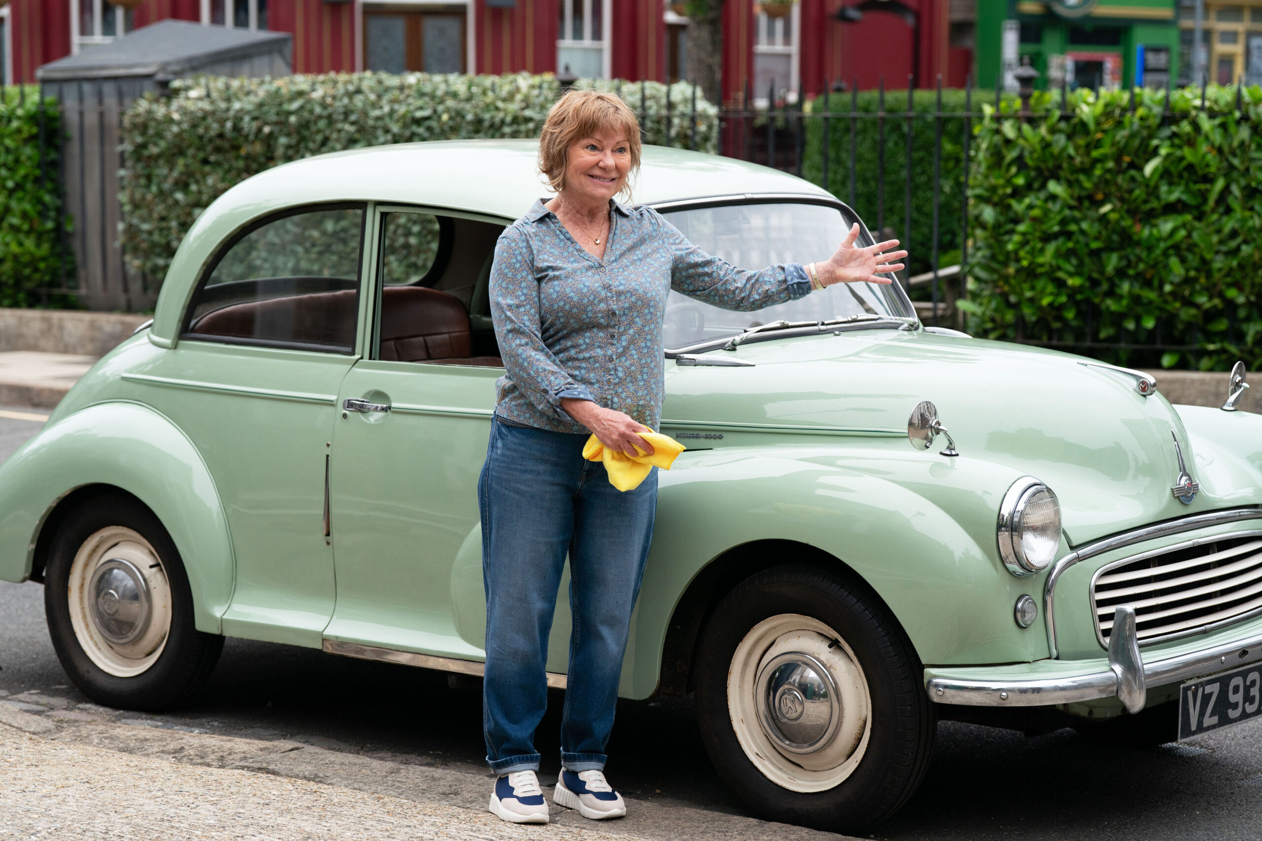 Julie beside an old car on EastEnders