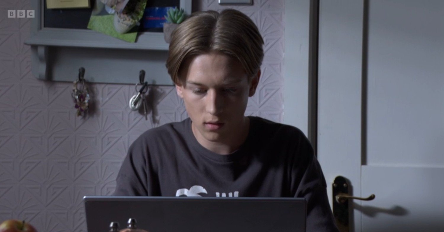Joel on his computer in EastEnders