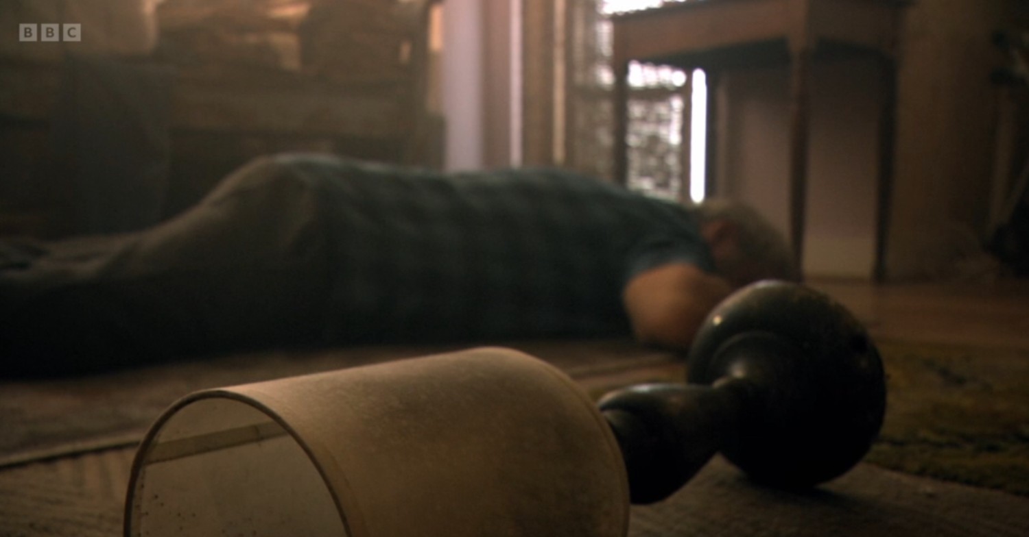 Greg Dolan unconscious next to a lamp