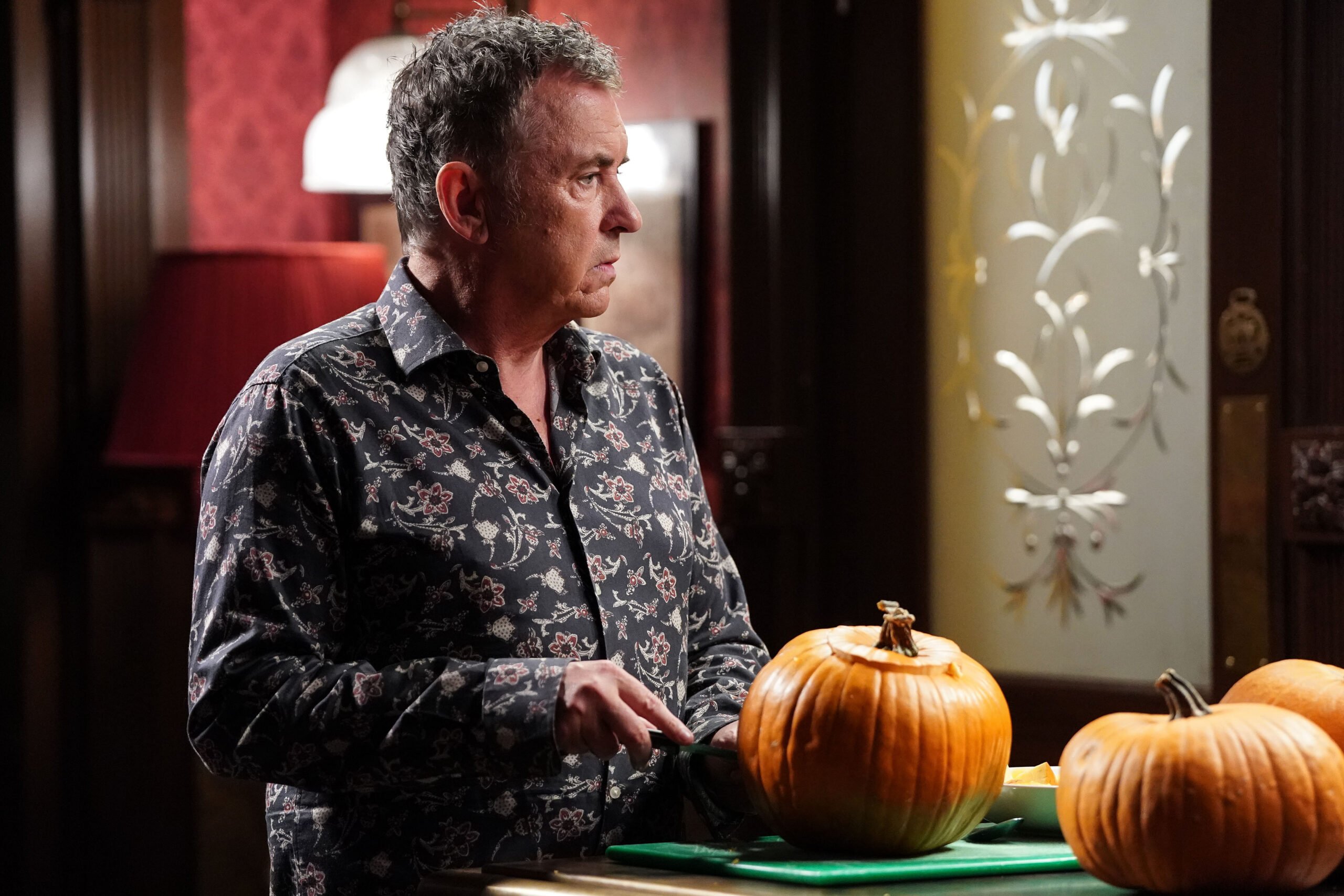 Alfie looks worried as he stands by some pumpkins on EastEnders