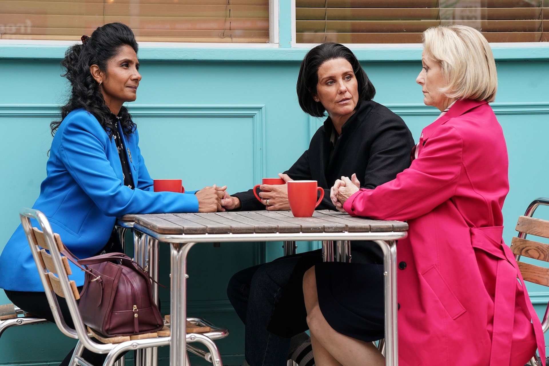 Suki and Eve talk with Norma outside the cafe