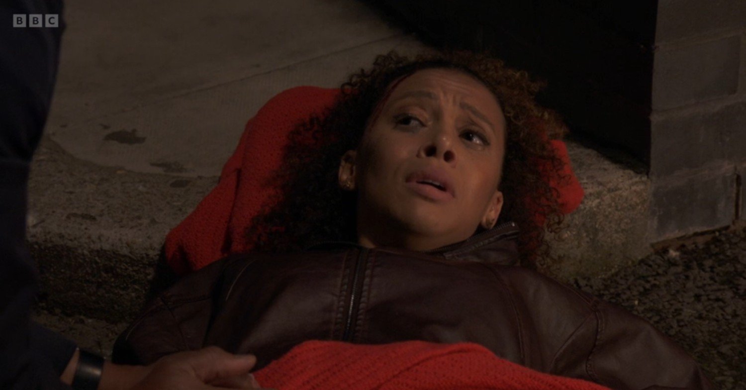 Gina being tended to by paramedics, looking pained