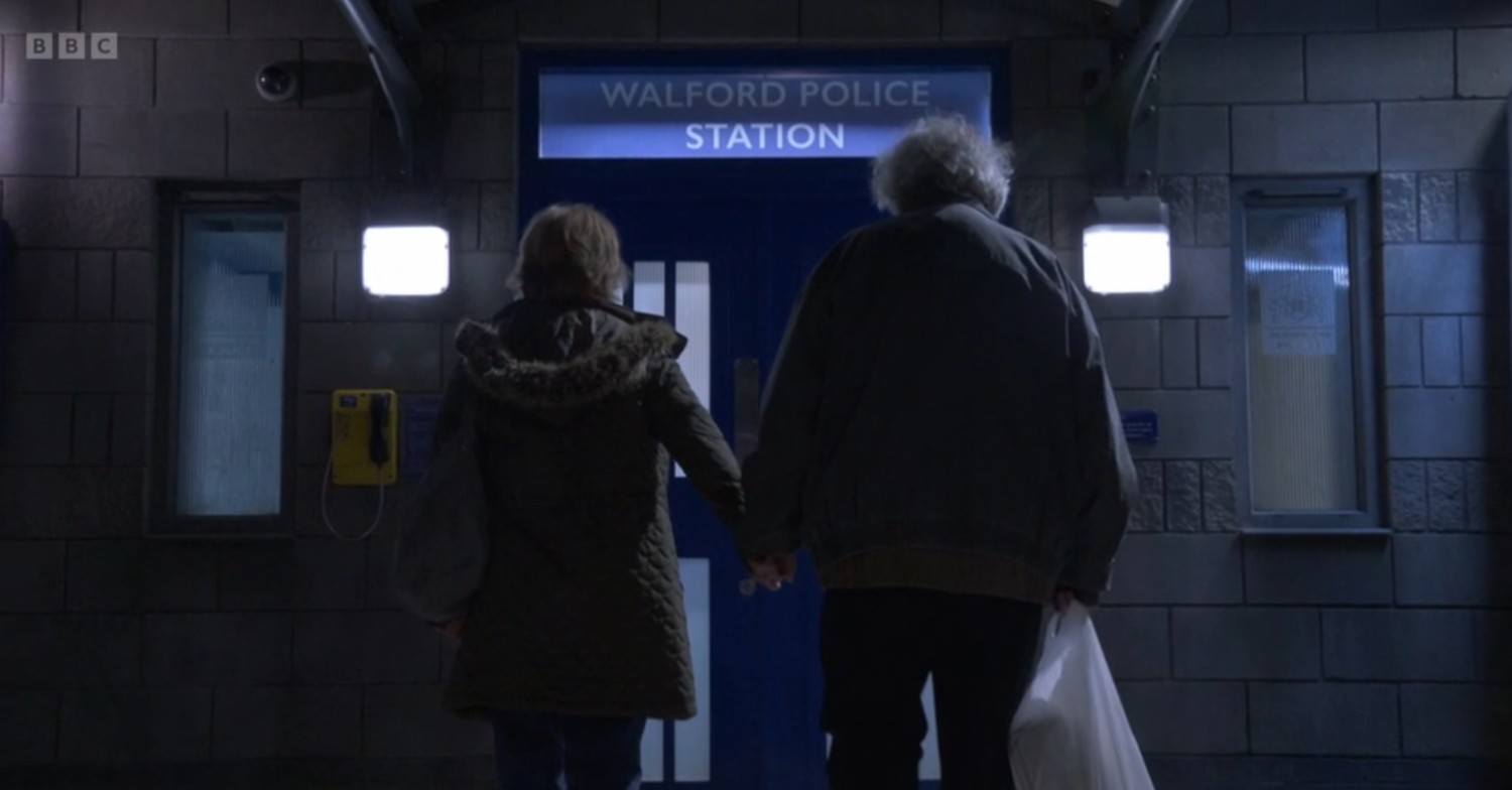 Nigel and Julie walk into the police station holding hands