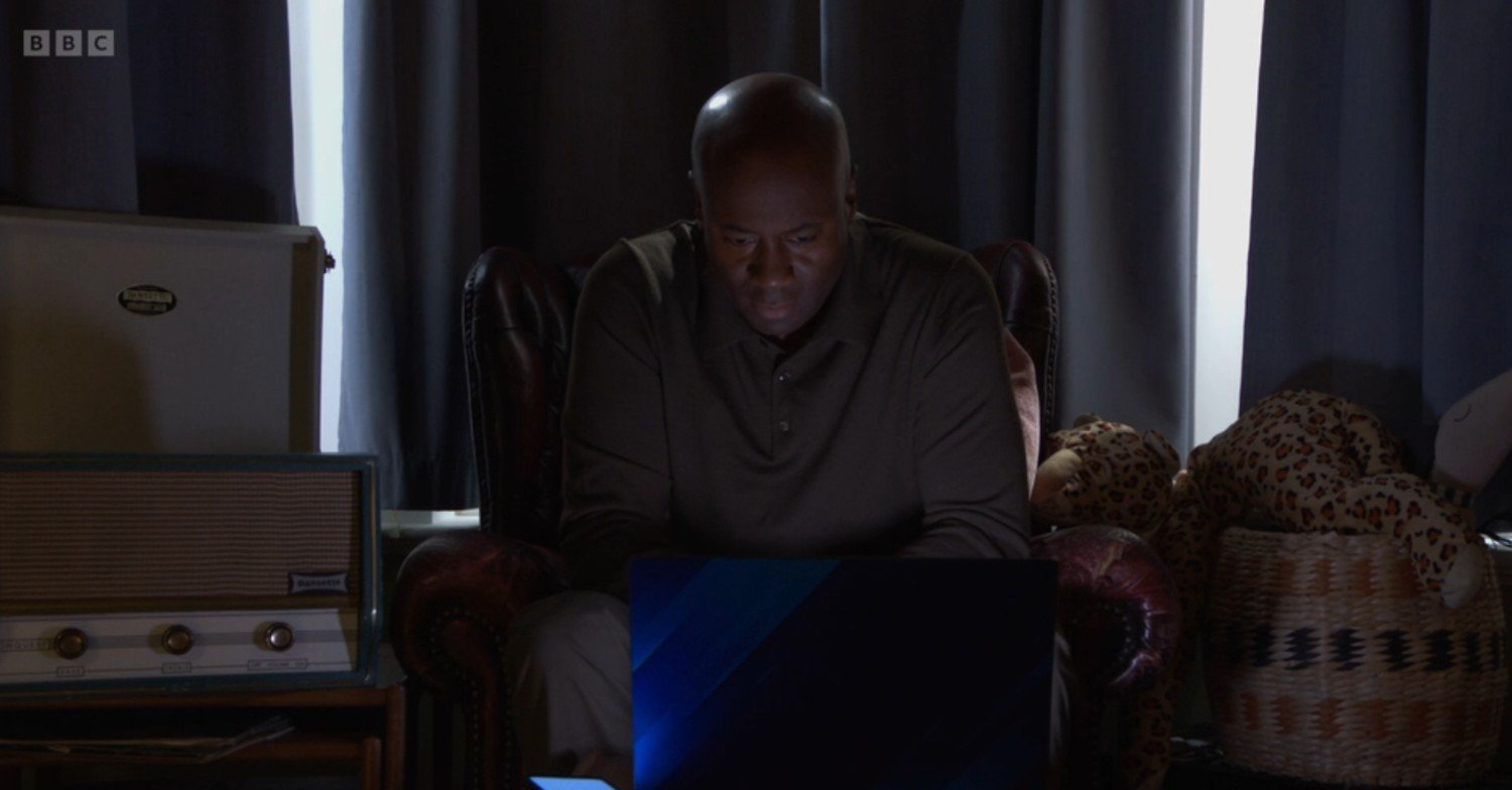 Anthony looking at pictures of Zoe in EastEnders