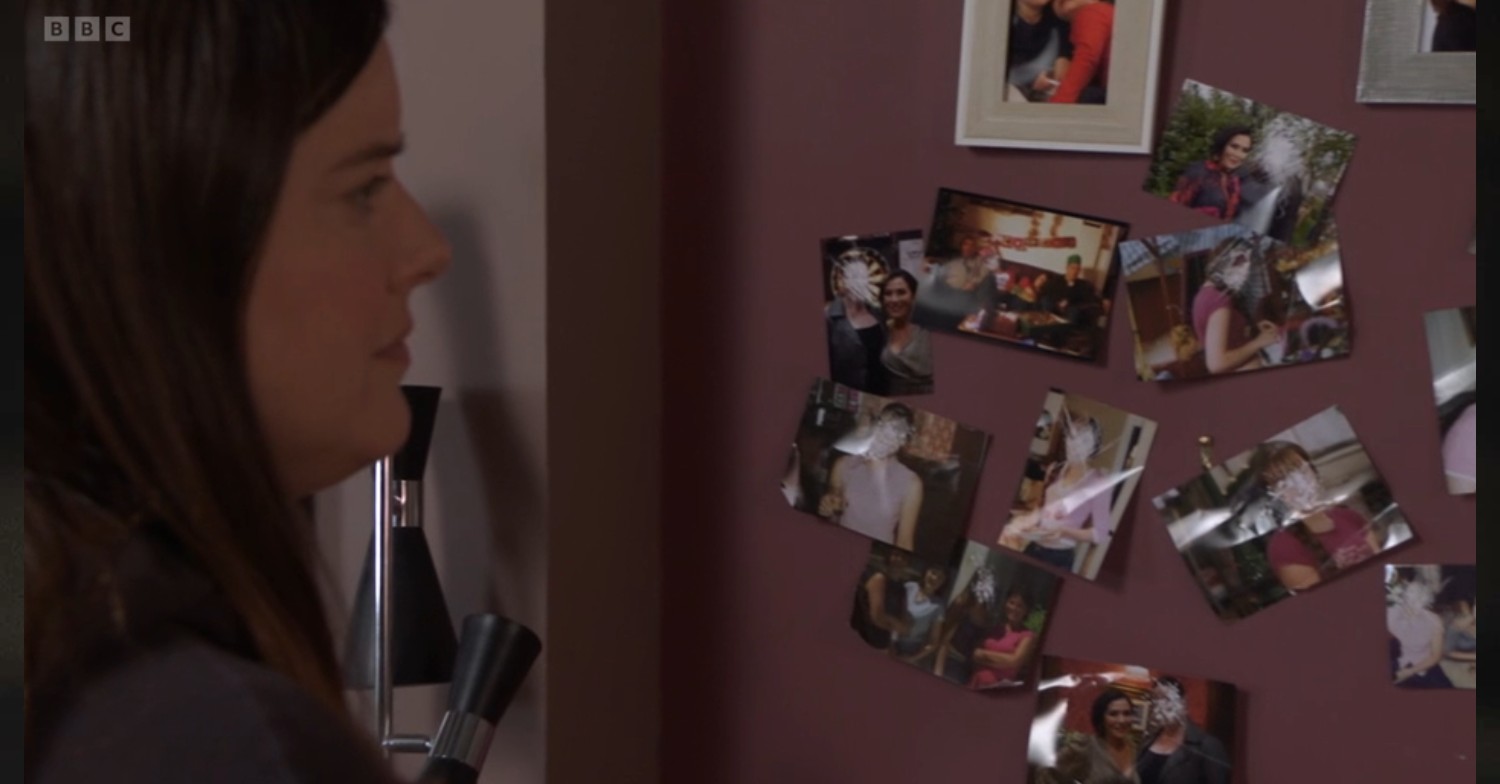 Zoe looks at defaced pictures in The Vic