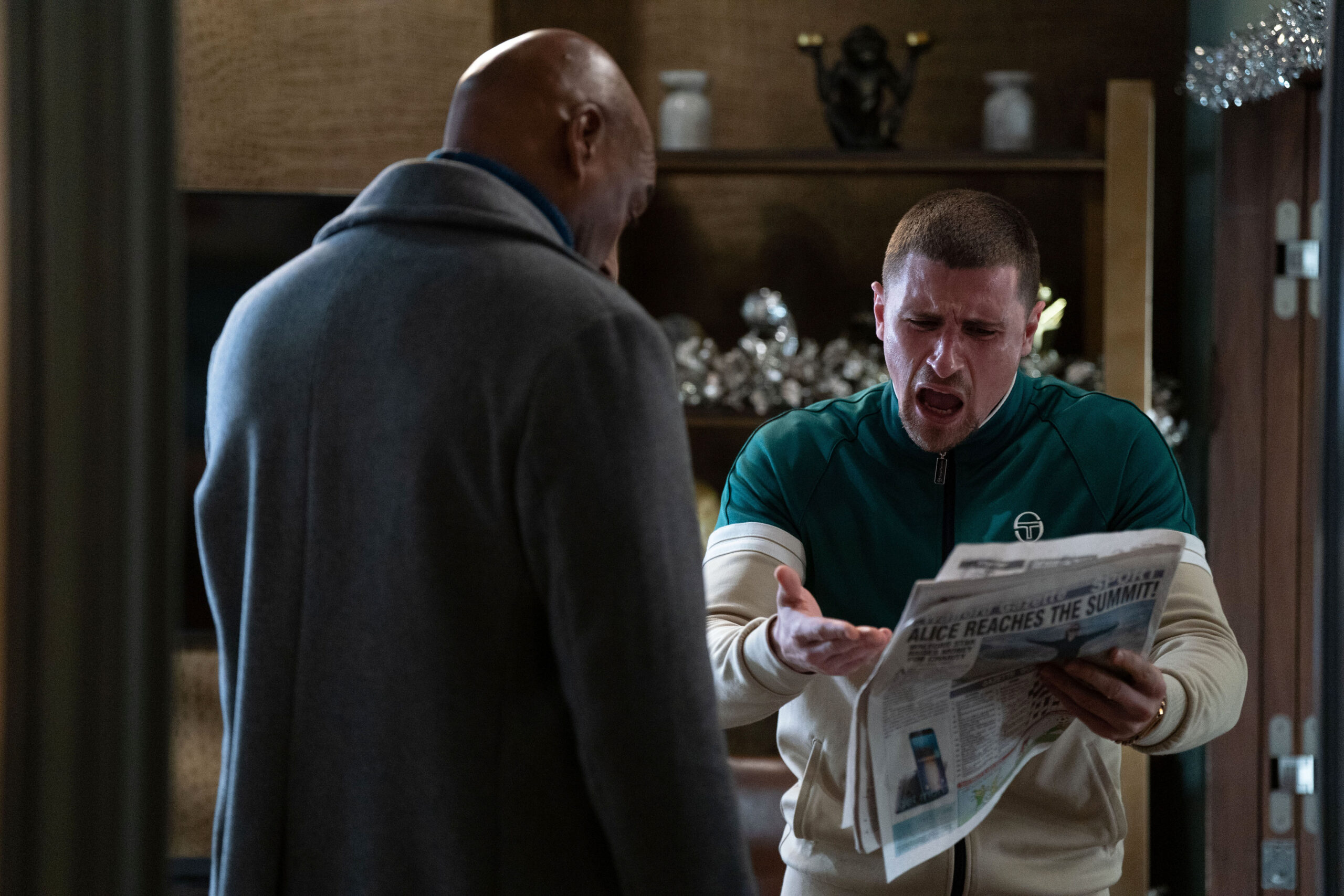 Harry looks horrified as he reads a newspaper to George