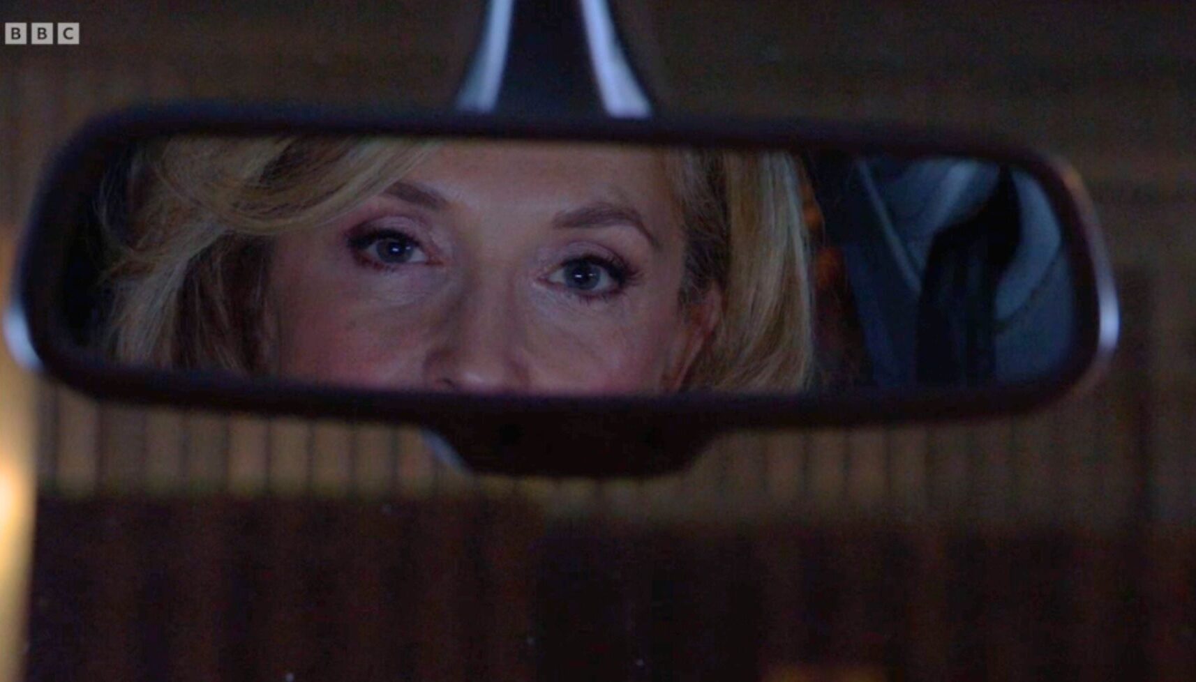 Chrissie Watts glares in the rear view mirror of a car