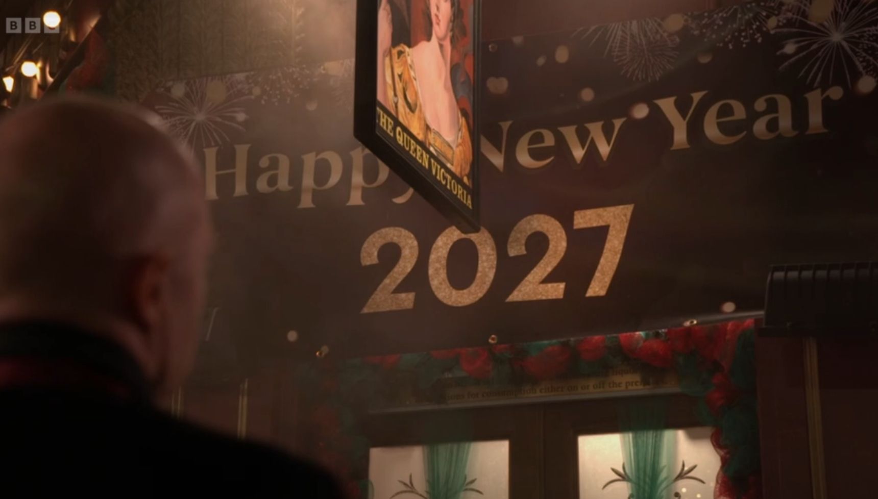 Max Branning looks up at a Happy New Year 2027 sign 
