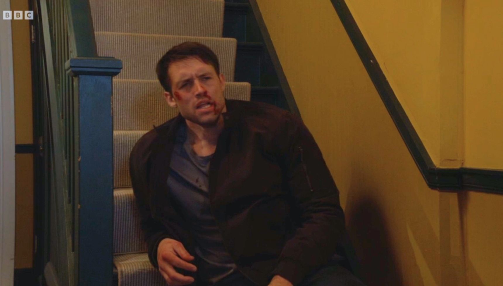 Mark on the stairs in Phil's home, battered and bloody 