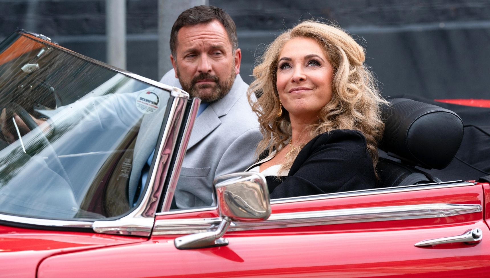 Jake and Chrissie in a red soft top car - EastEnders Jake Moon return