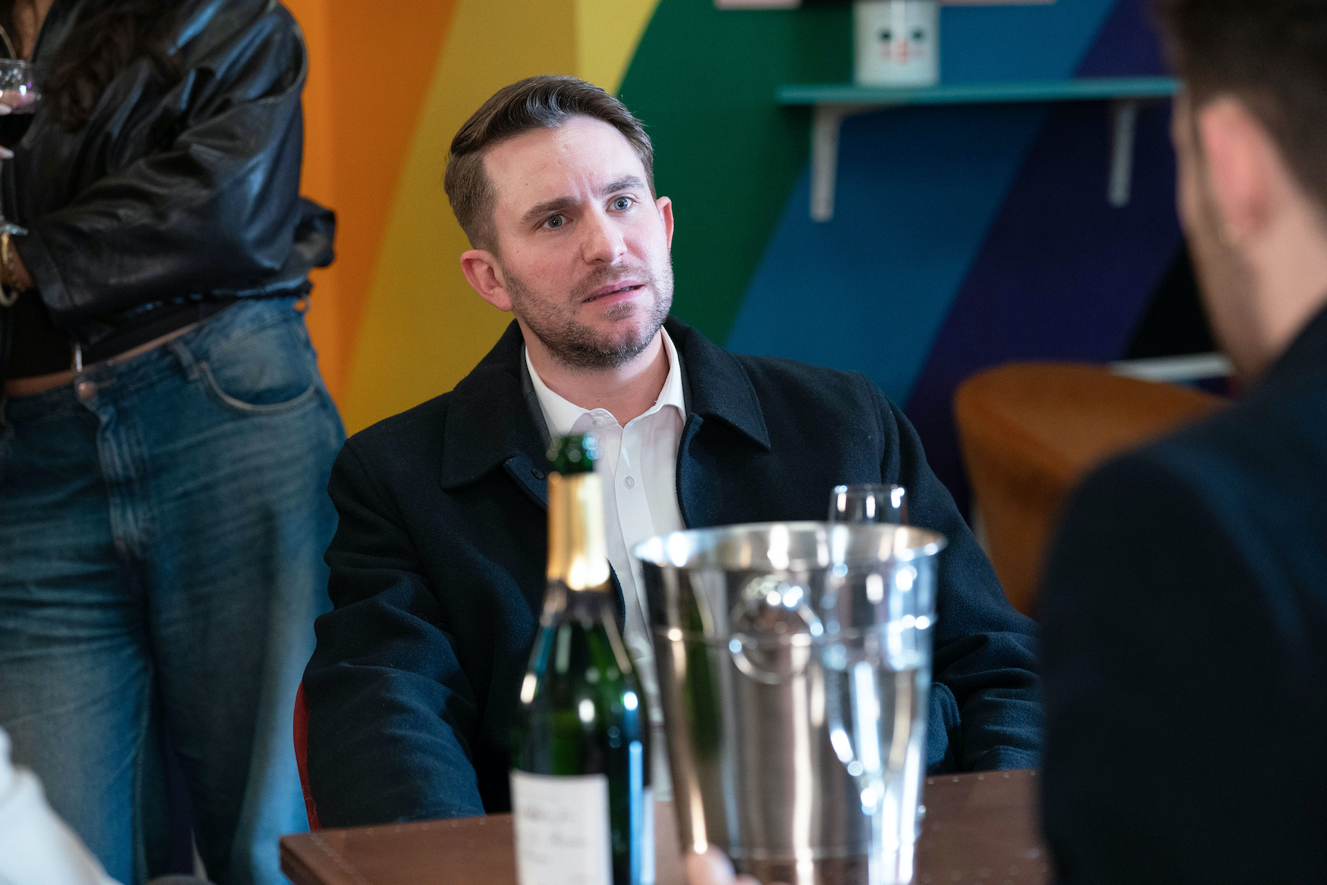 Callum looking shocked with drinks on the table in front of him in EastEnders spoilers