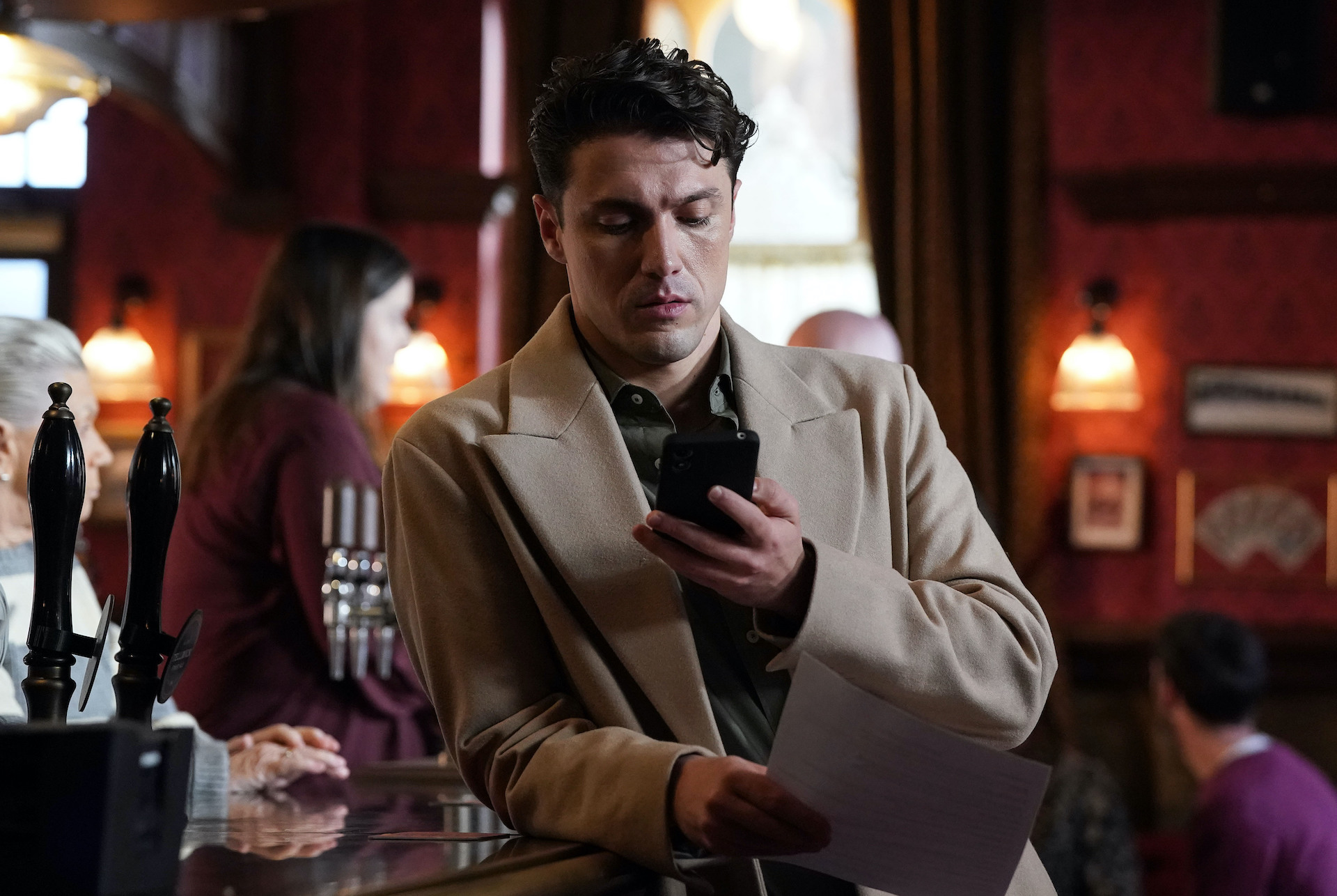 Tim on his phone in The Vic