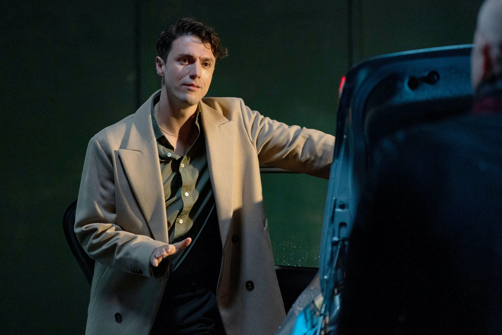 Tim standing by a car in a cream coat 