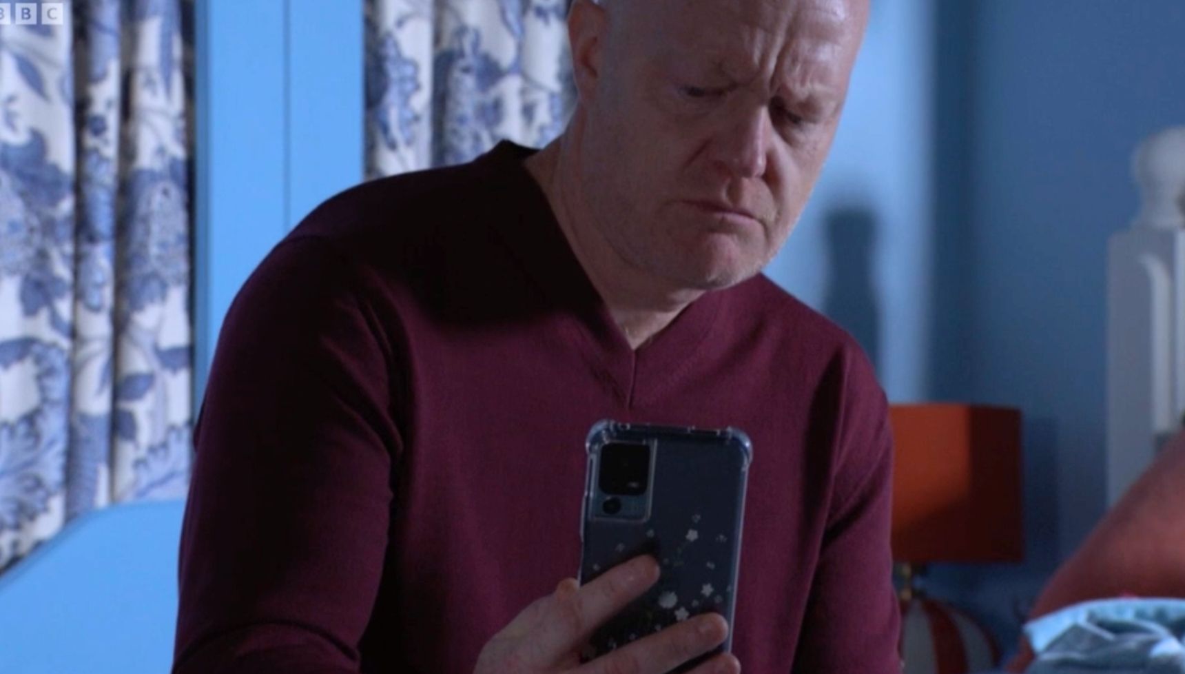 Max holding Jasmine's phone in EastEnders 