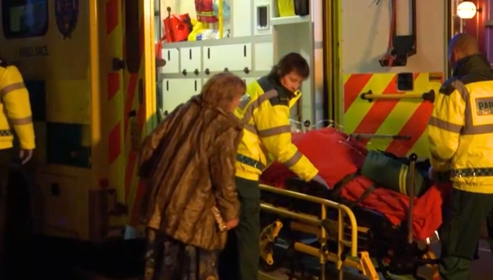 Nigel being loaded into the back of an ambulance while Julie looks on