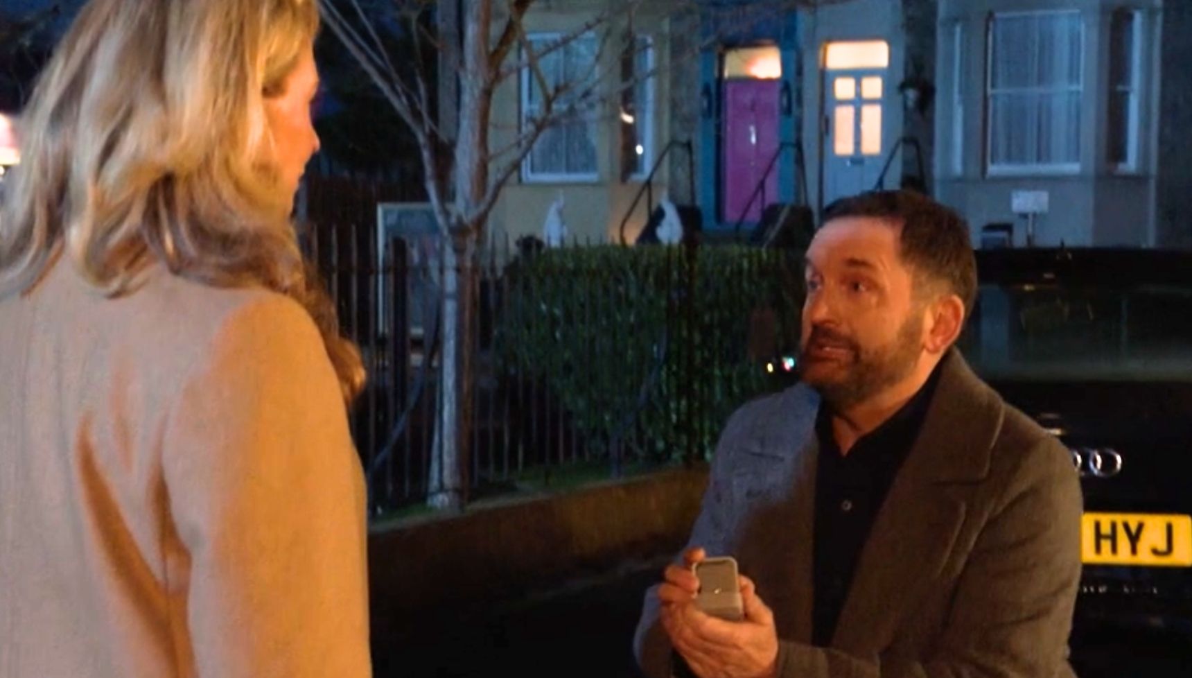 Jake on one knee proposing to Chrissie in the Square