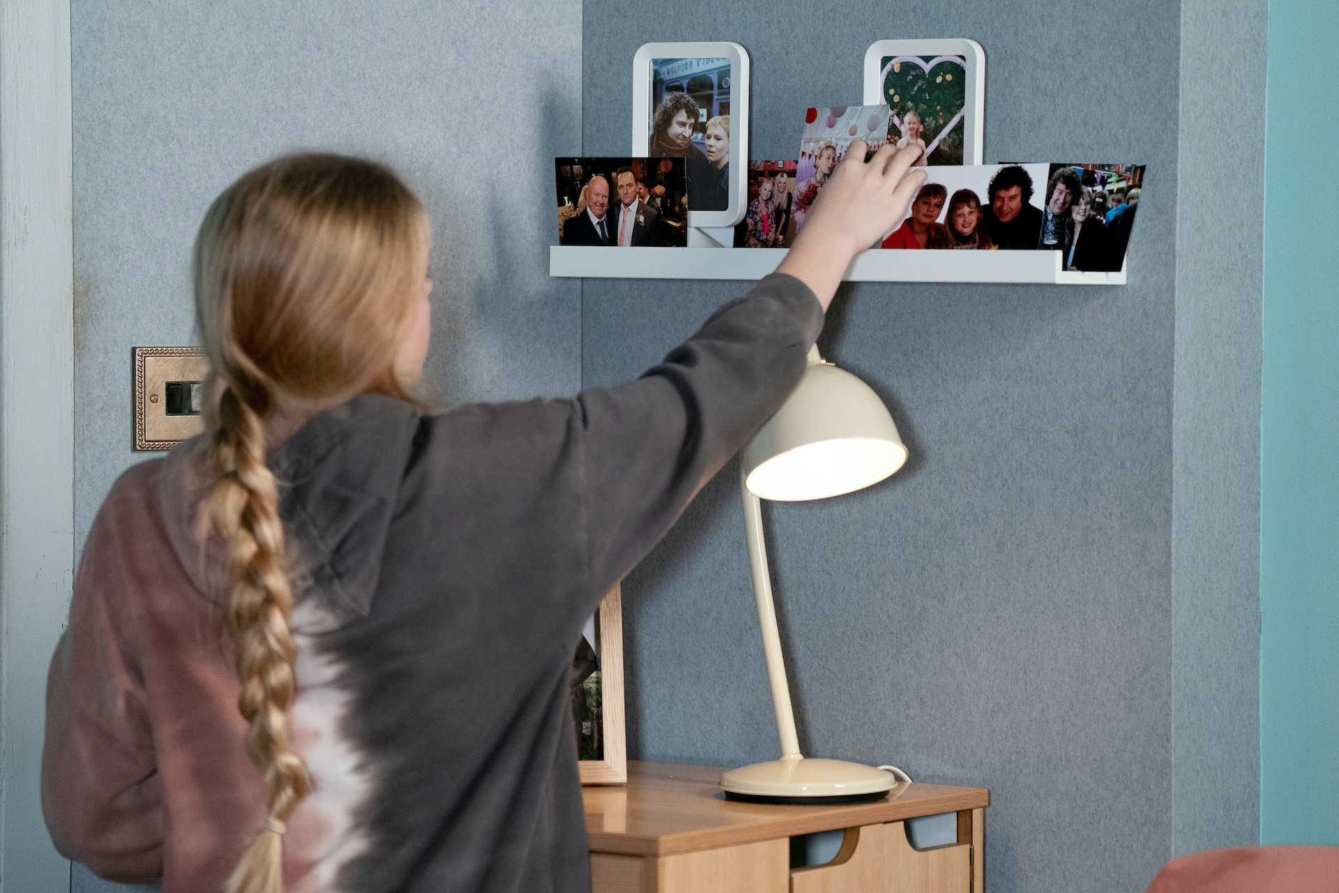 Lexi looking at a photo of Nigel in EastEnders spoilers