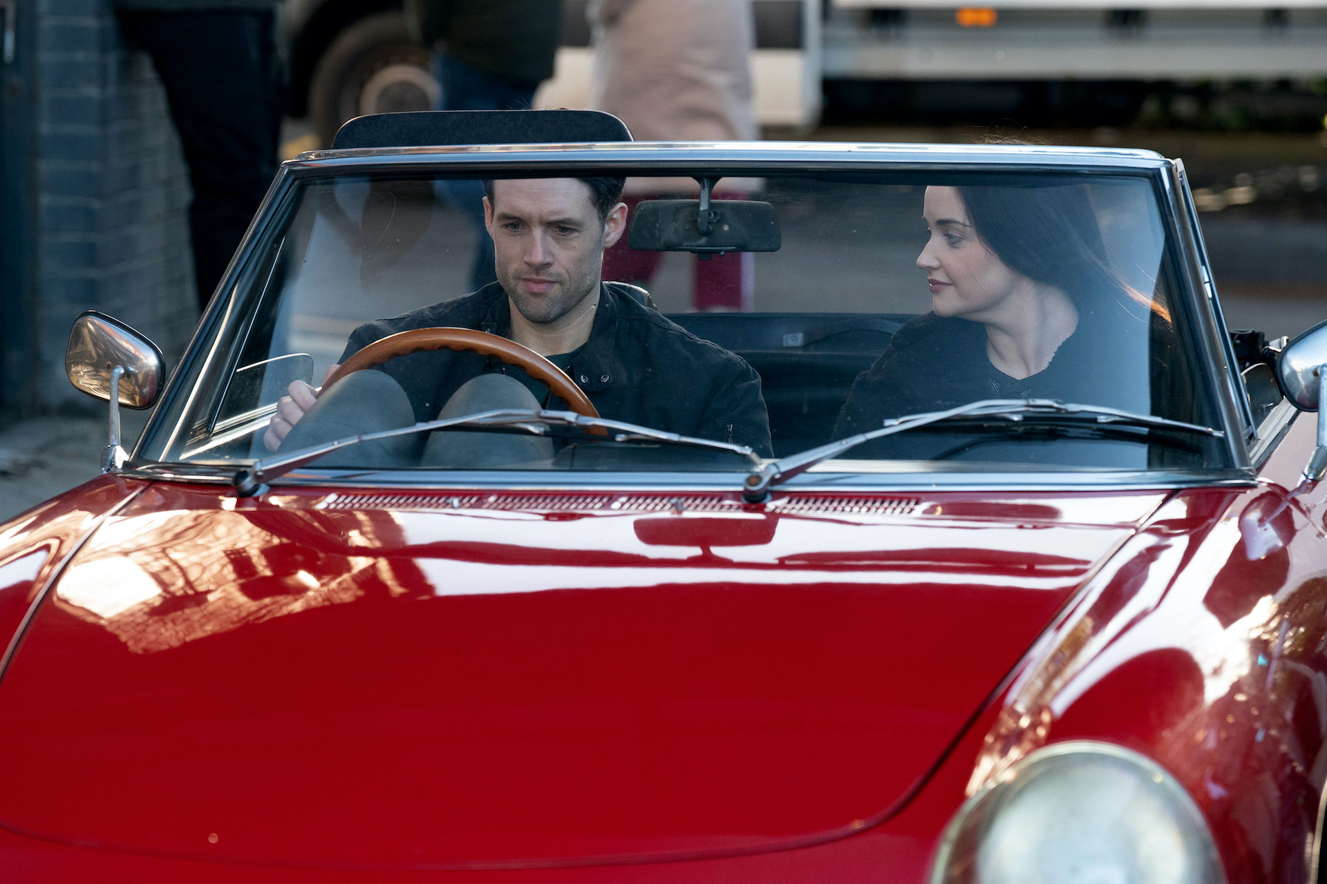 Mark and Lauren in a classic car driving together 