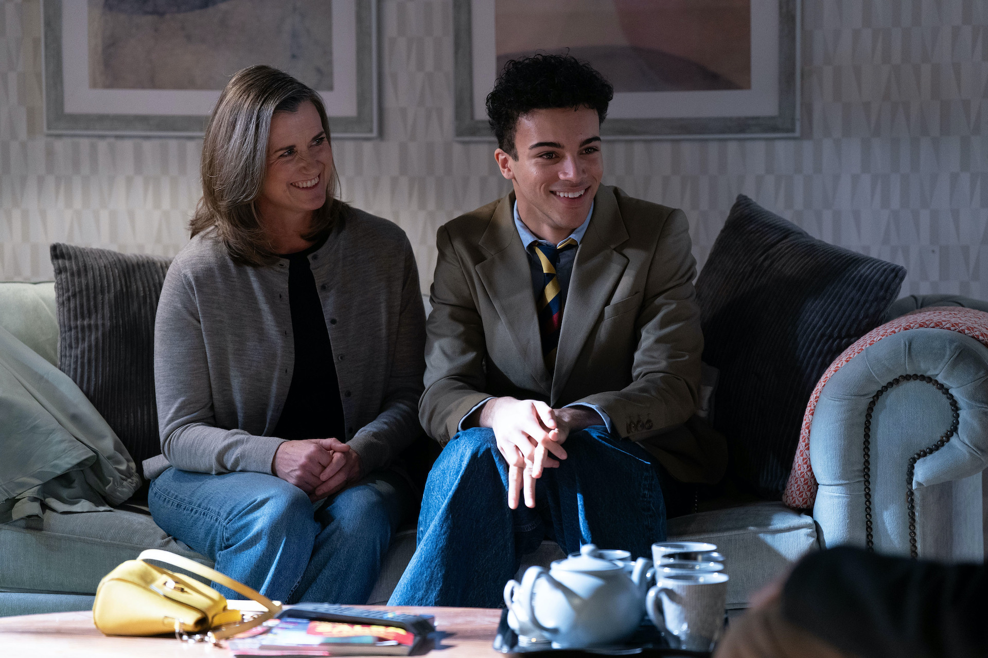 Sandra and Josh smiling while sitting on Jack and Denise's sofa 