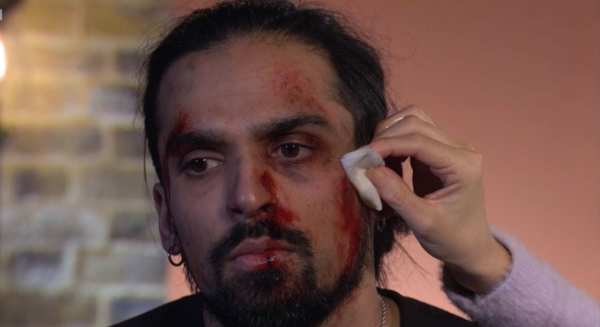 Priya cleans Ravi's wounds at home in the living room