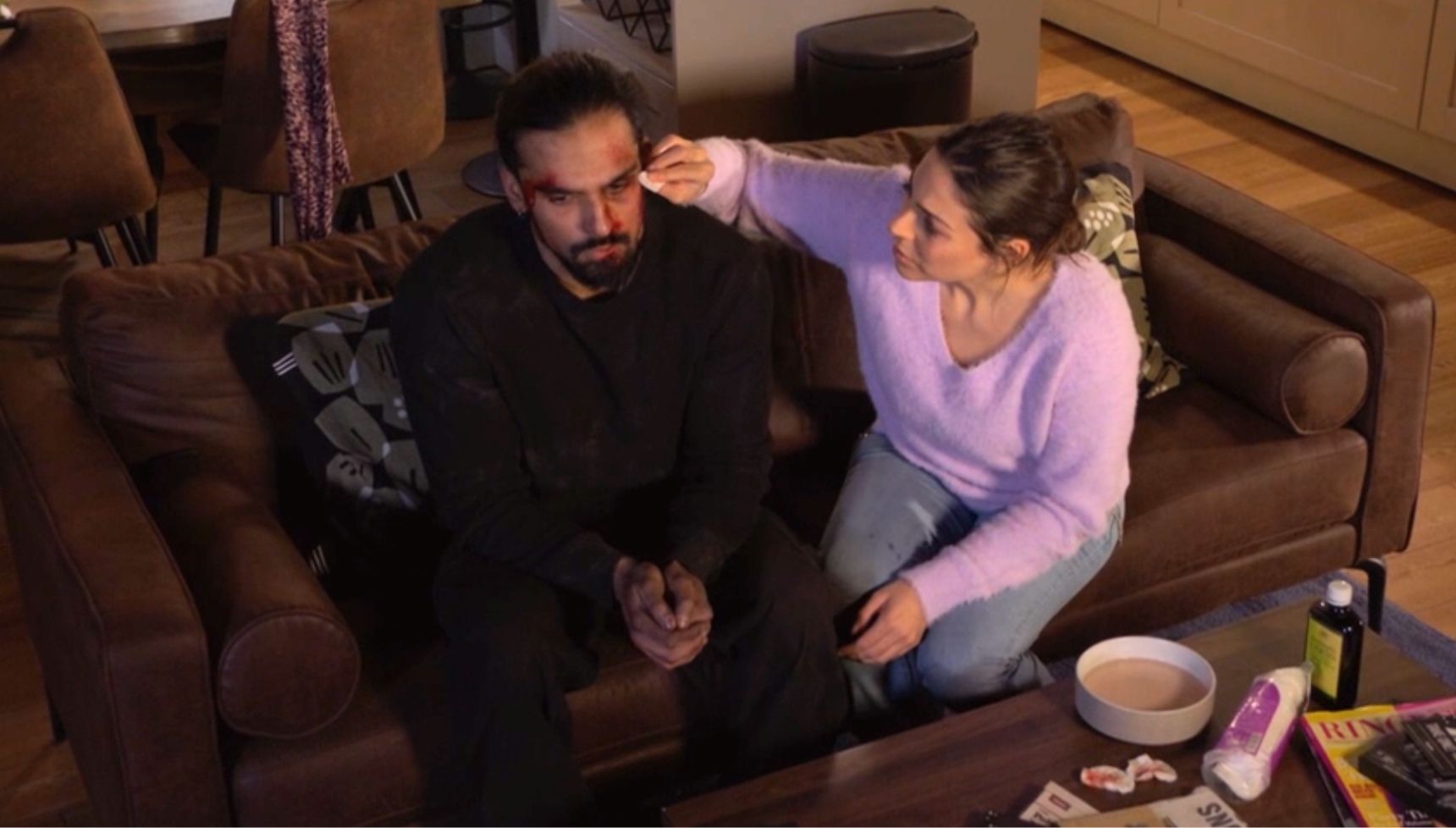 Priya cleans Ravi's wounds at home in the living room