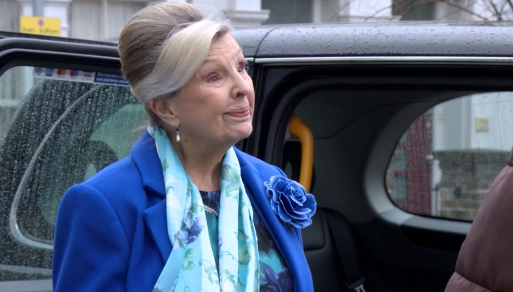 Cora smiling as she gets into a taxi