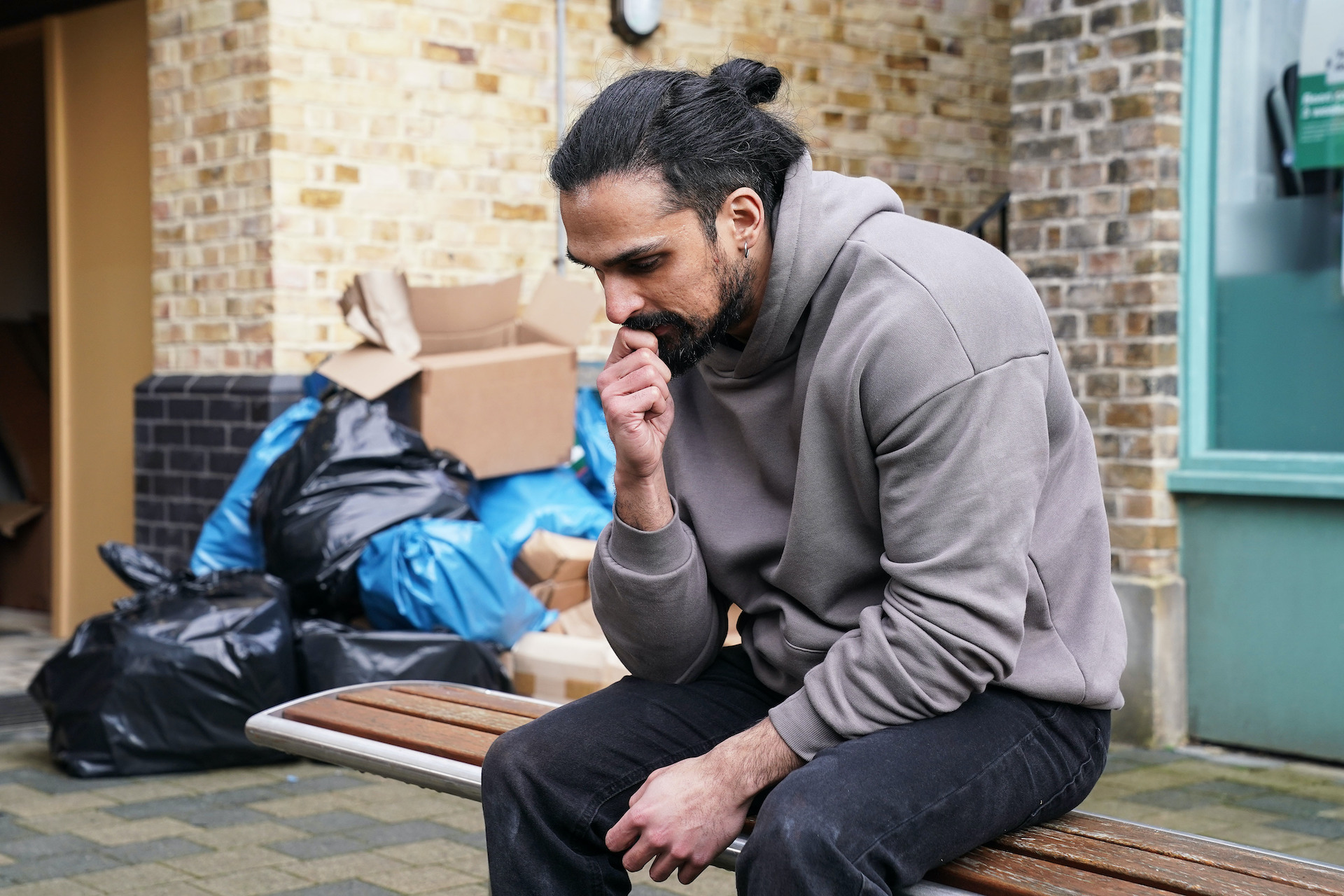 Ravi on a bench looking stressed 