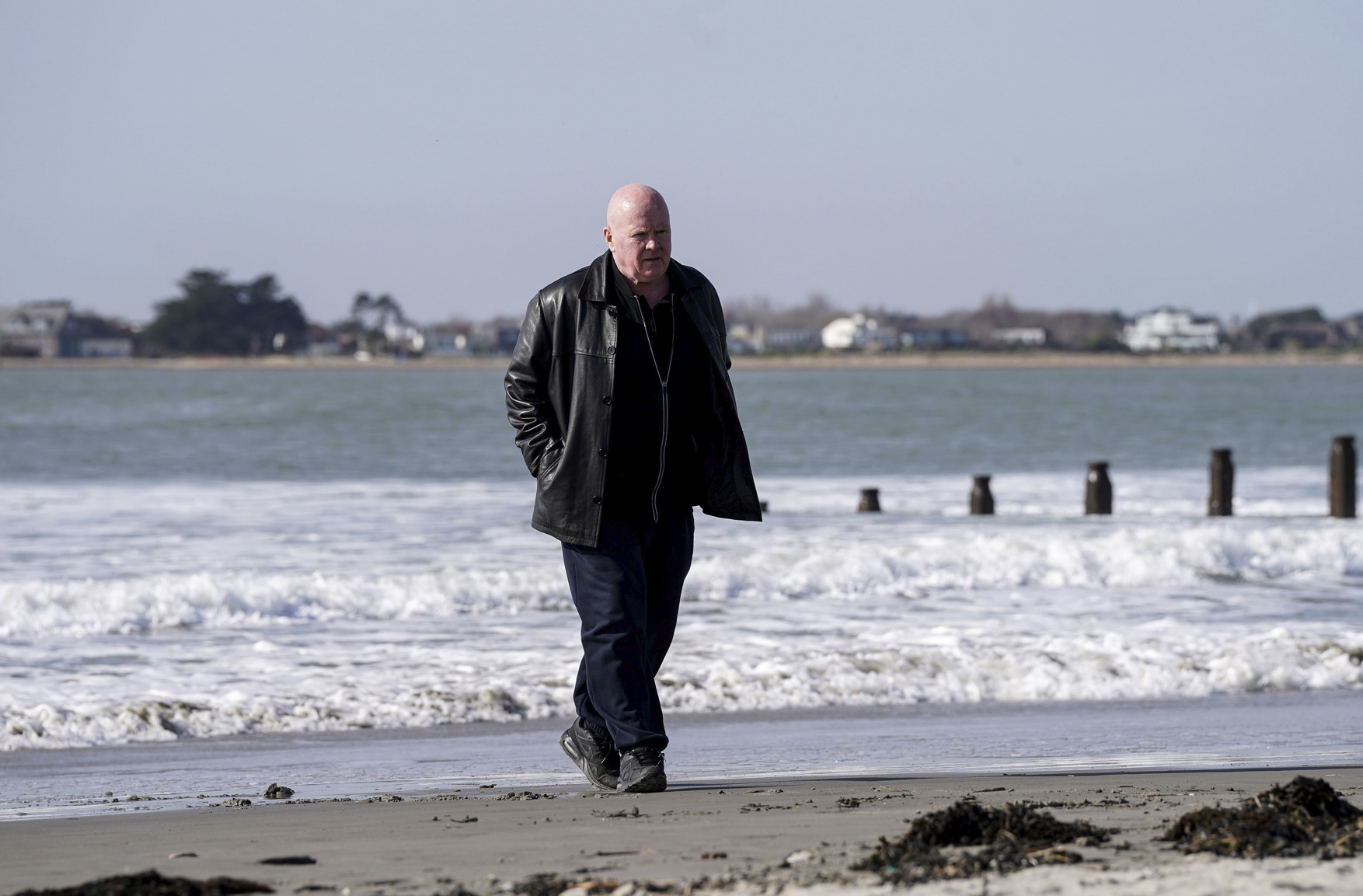 Phil walking along the beach in EastEnders