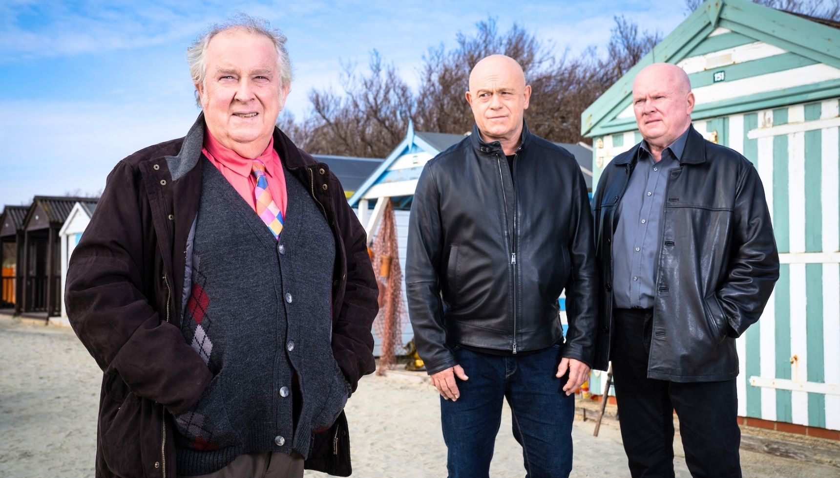 Grant, Nigel and Phil all standing in front of beach huts together