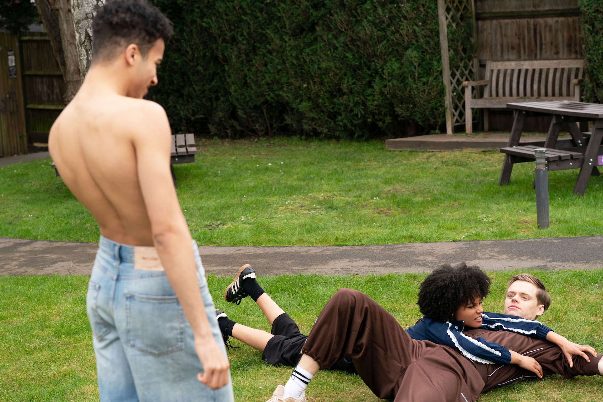 Josh with his t-shirt off in the park as Oscar looks on in EastEnders spoilers