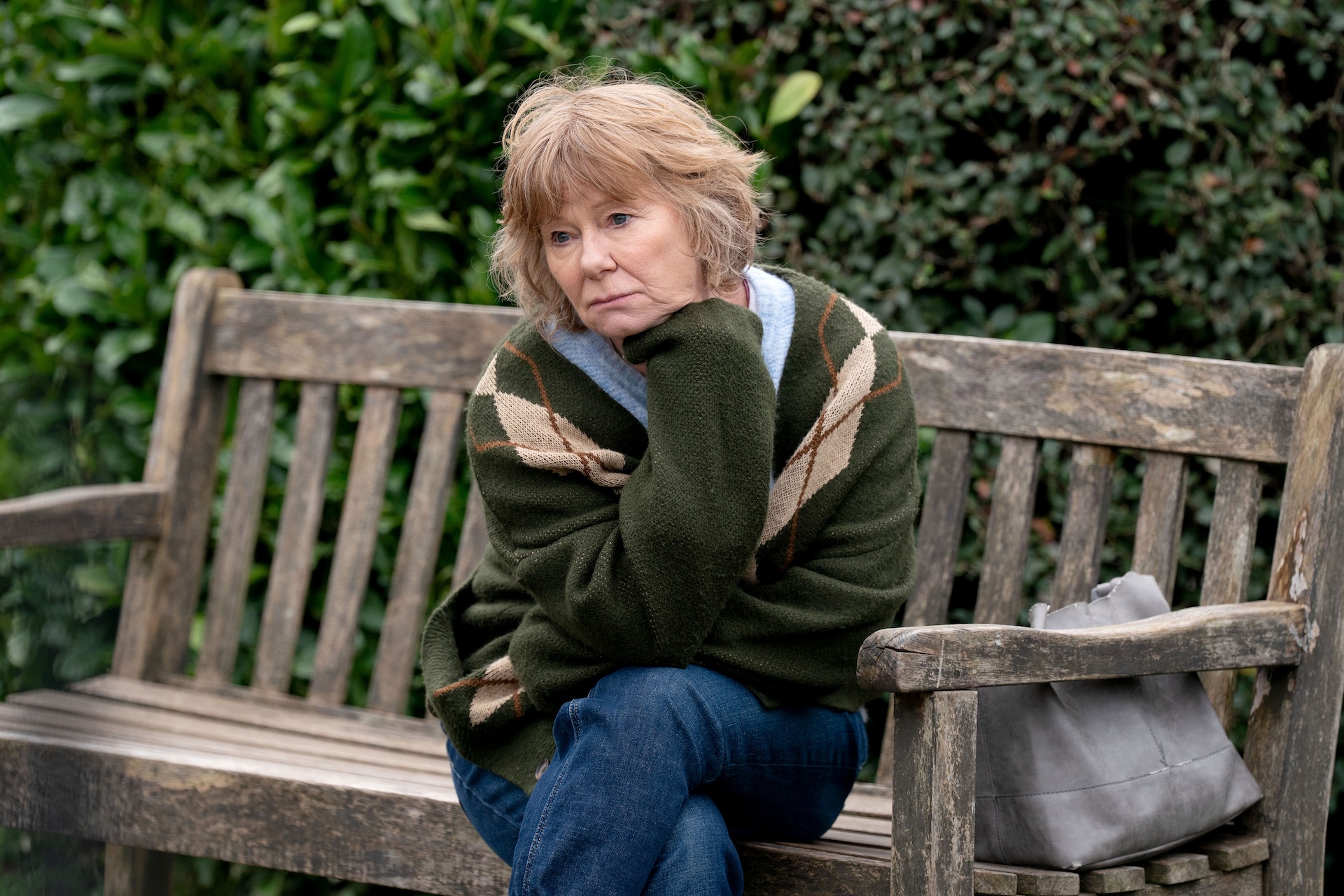 Julie looking sad on a bench 