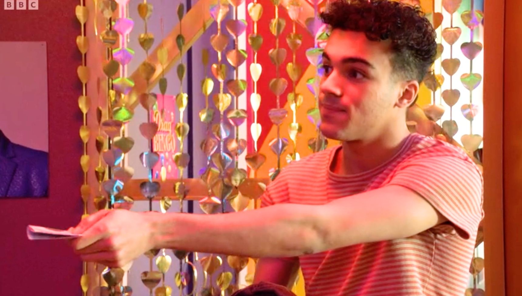 Josh holding out cash and Oscar is surprised in EastEnders 