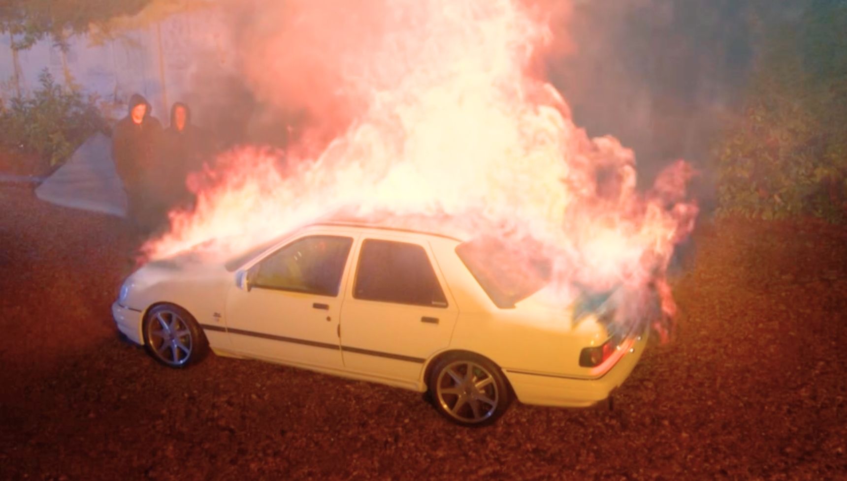Sam and Mark watch a car on fire in EastEnders