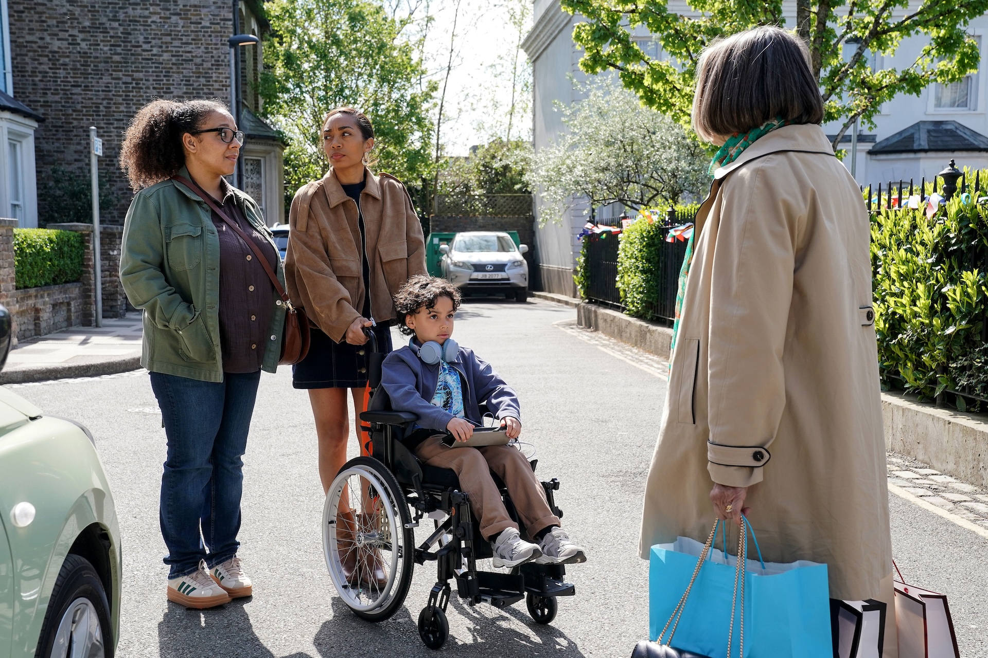 Chelsea and Libby with Jordan in a wheelchair as they talk to Sheila in the Square in EastEnders spoilers 