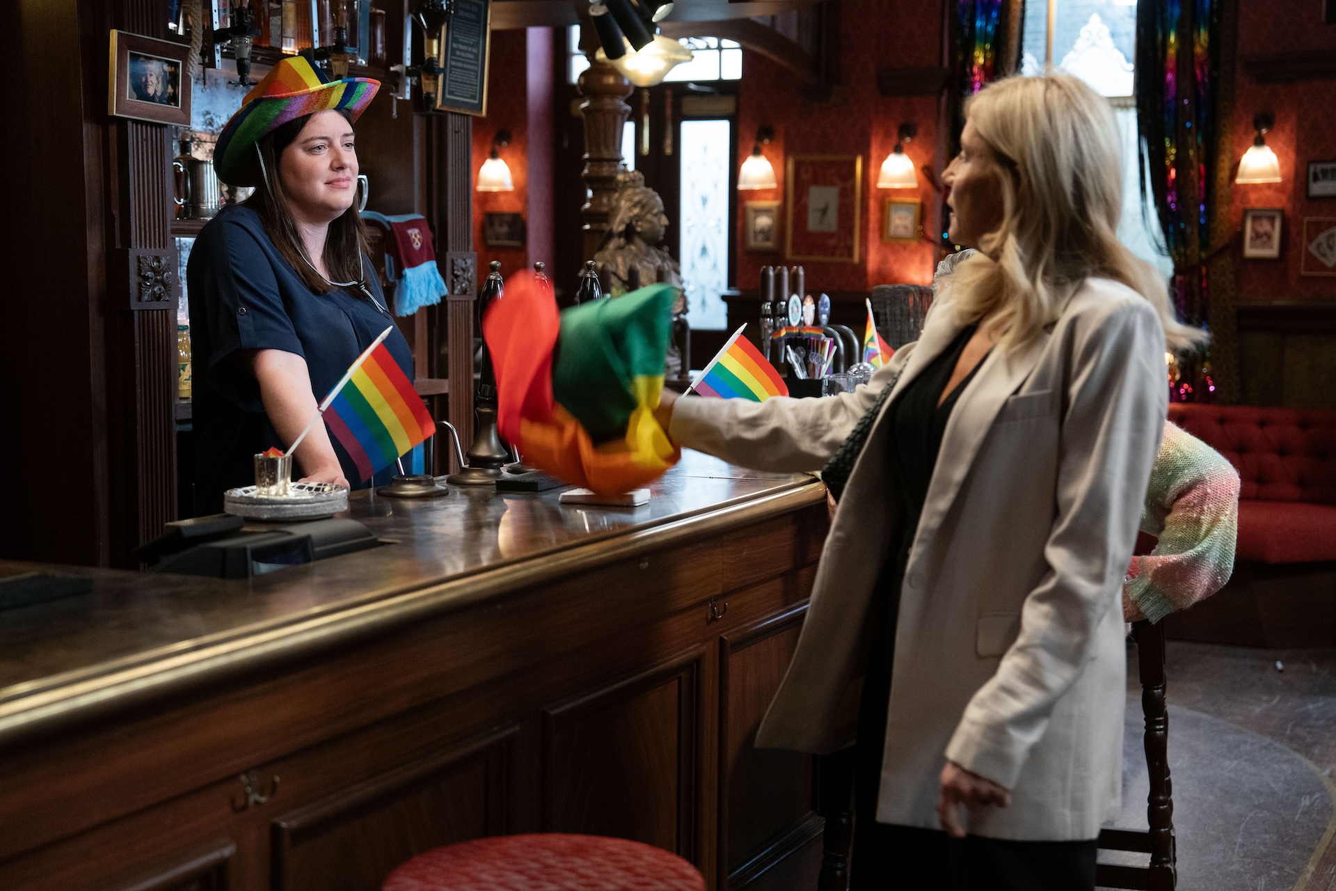 Zoe and Cindy arguing in The Vic with Pride flags everywhere 