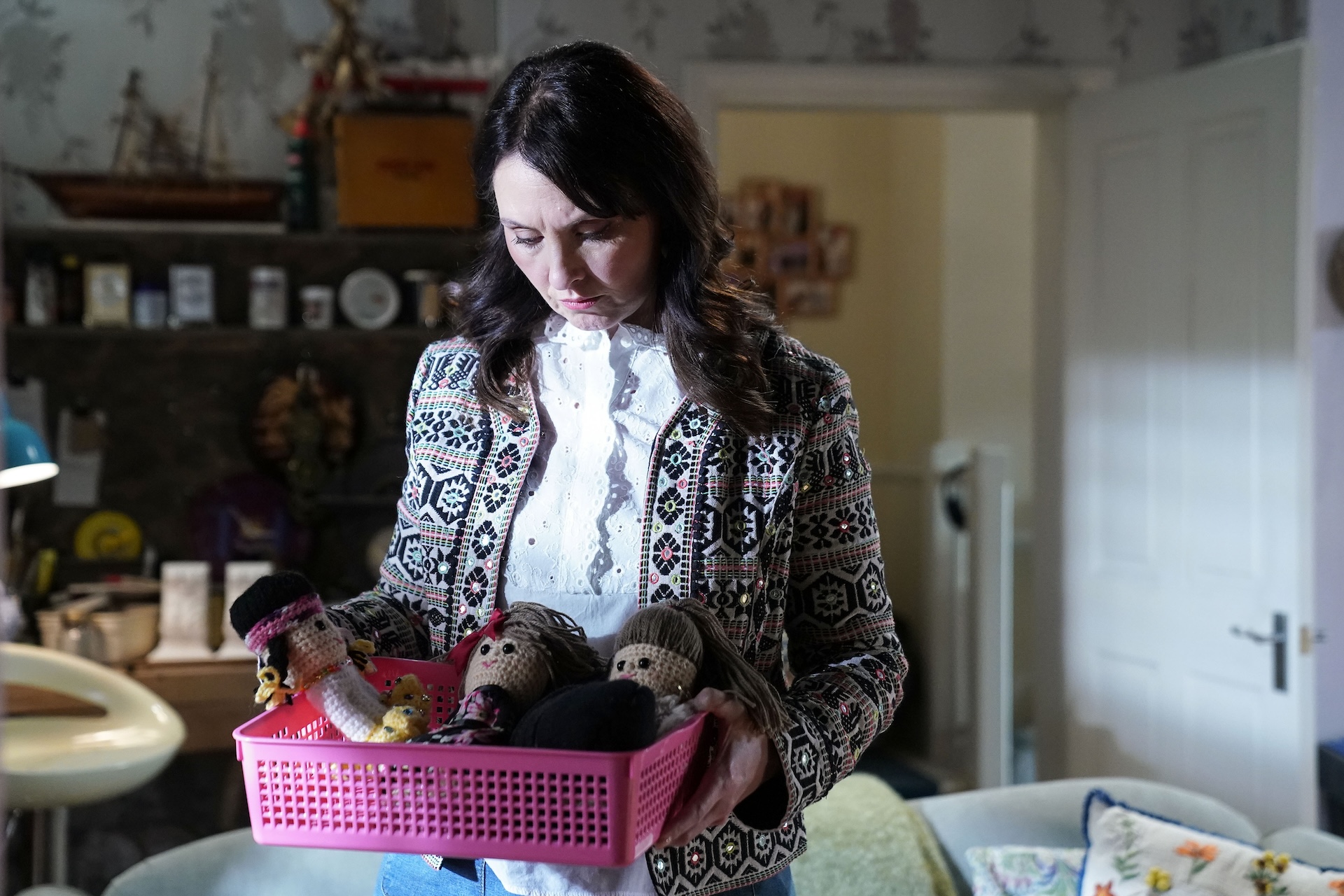 Honey looking at a basket of crocheted dolls 