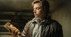 Jack Lowden as Kenneth Noye starring at a gold bullion in The Gold