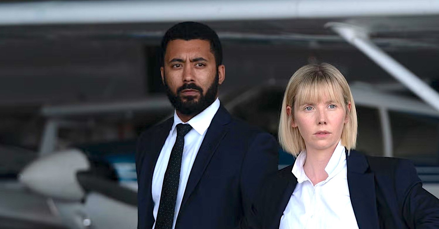 Karen Pirie S1 Karen DS Phil Parhatka, played by Zach Wyatt, with DS Karen Pirie, played by Lauren Lyle, both in black suits with white shirts