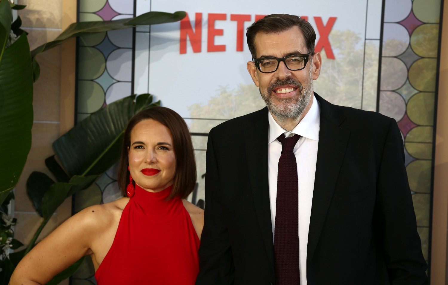 Richard Osman with Ingrid Oliver, stood in front of a Netflix hoarding at The Thursday Murder Club premiere