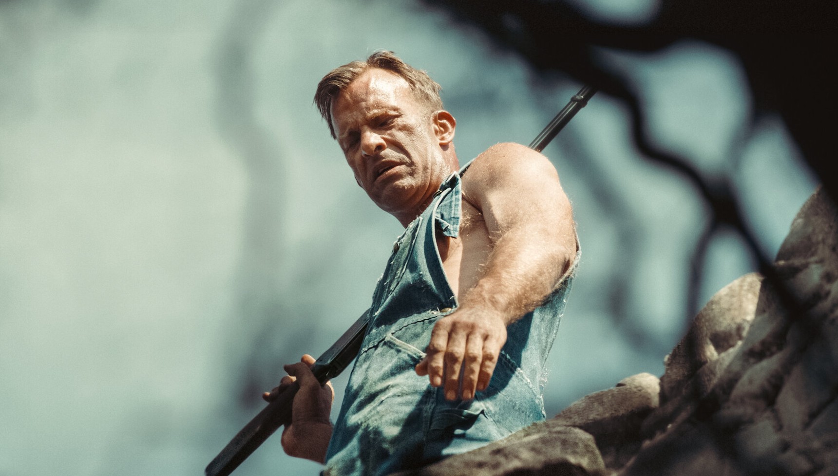 Thomas Jane holding a shovel and looking into a hole in 1922