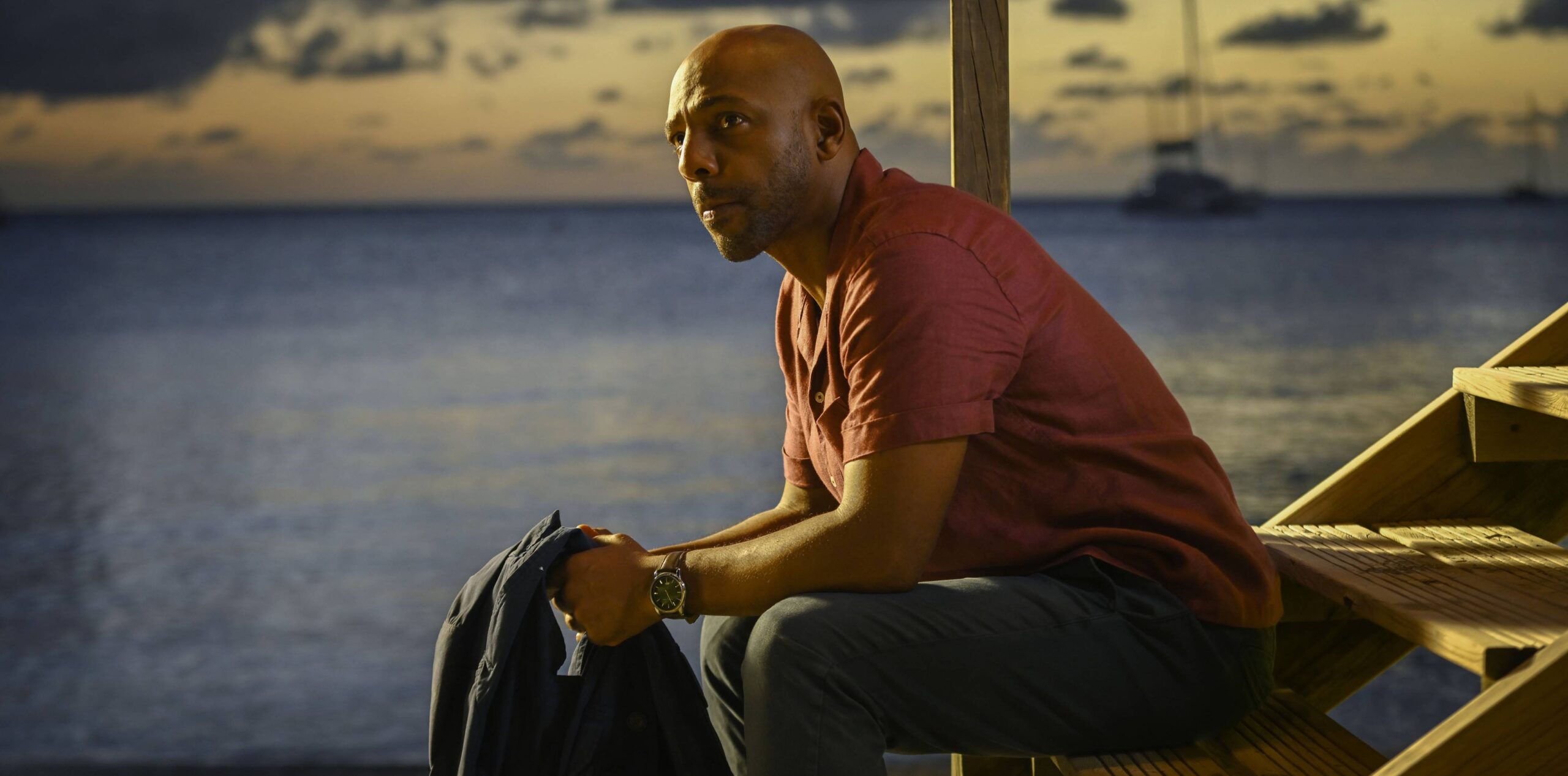 DI Mervin Wilson looking thoughtful by the sea in Death in Paradise