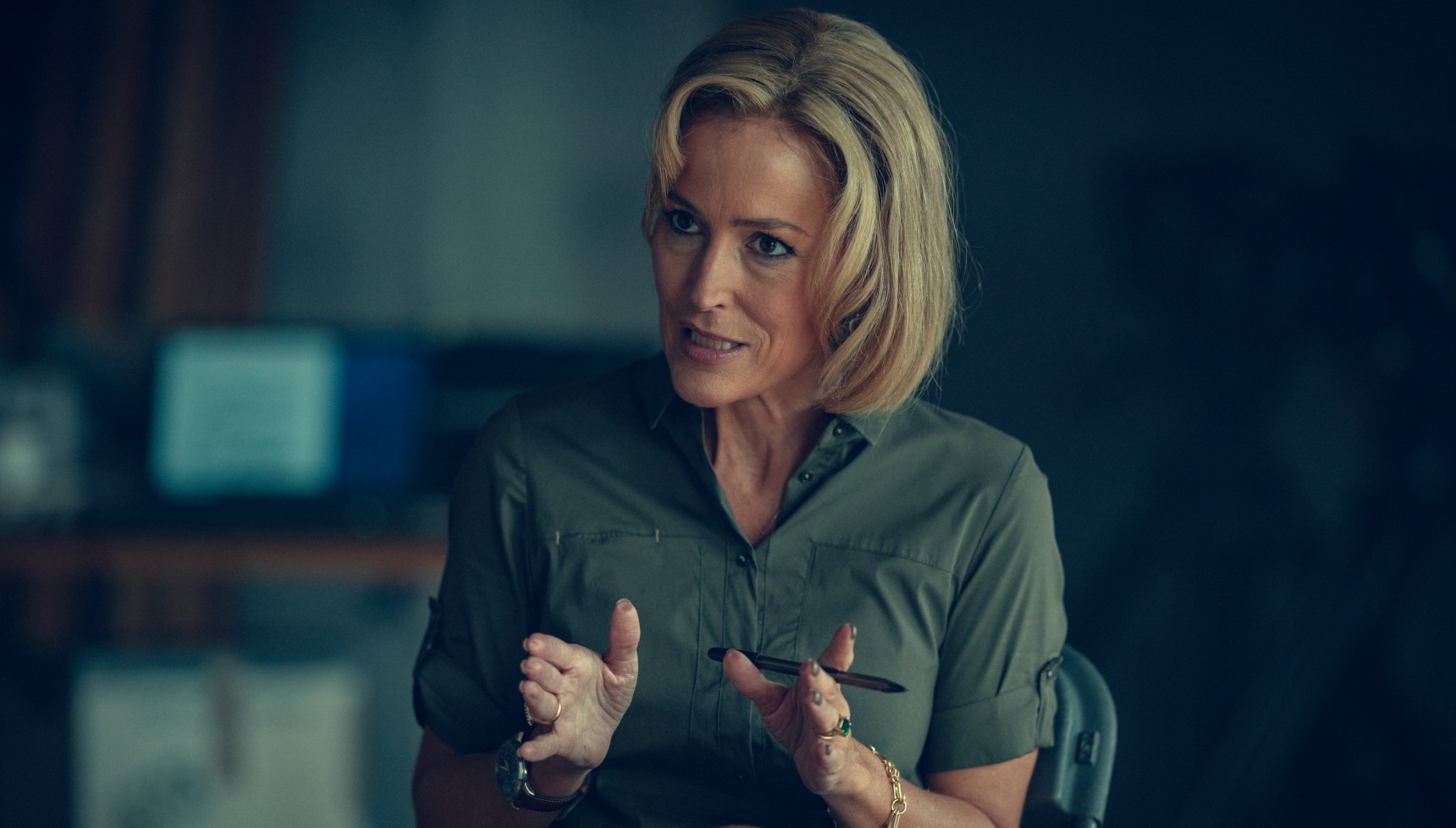 Blonde-haired woman speaks intently towards somebody off camera