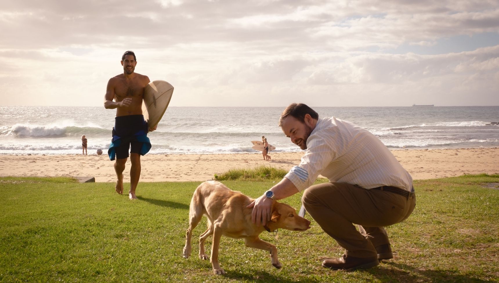 Colin and Glenn with Frankie the dog at the beach in return to Paradise