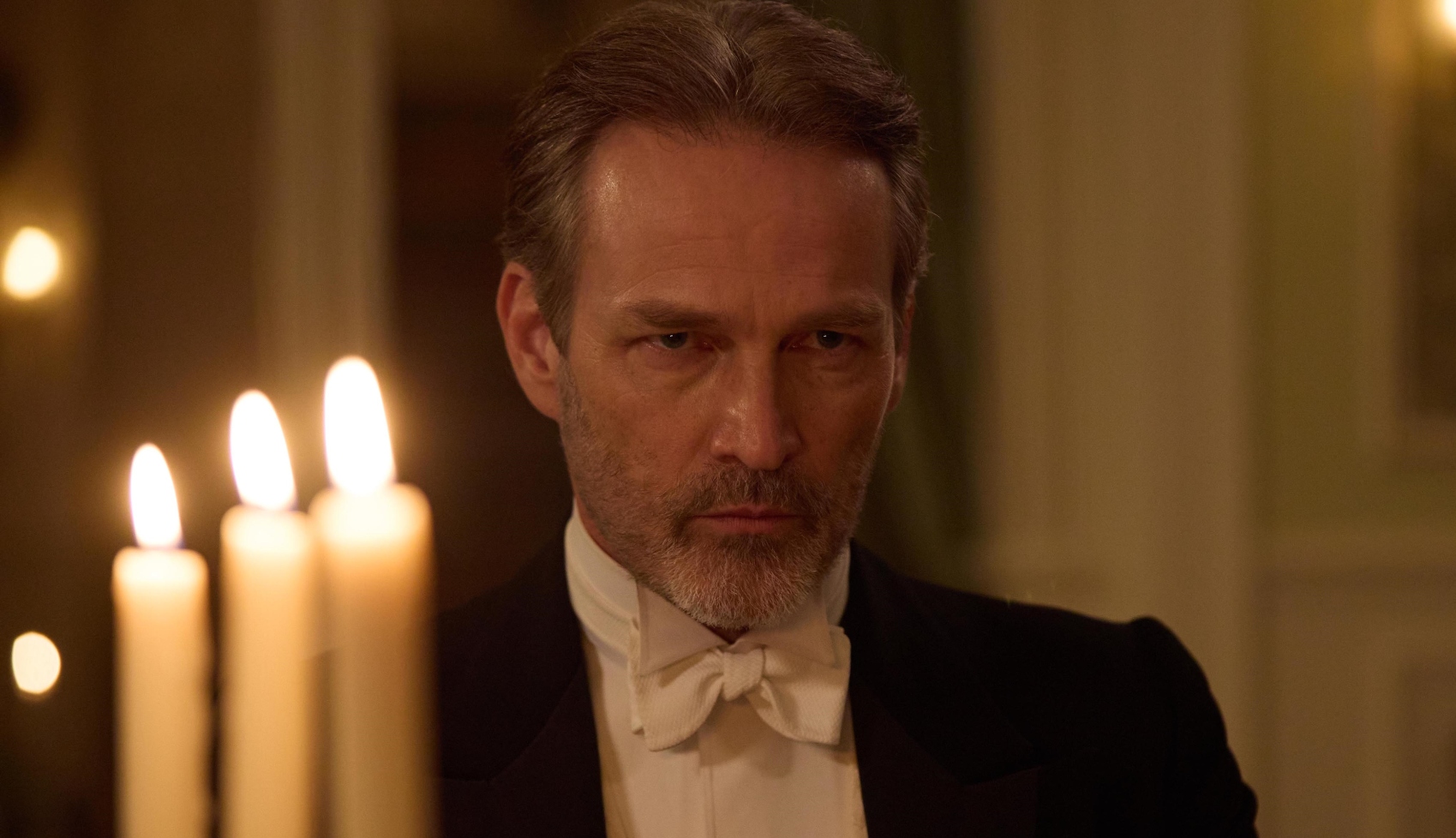 Stephen Moyer as Jolyon Sr in The Forsytes wearing a dark suit and a cross look on his face